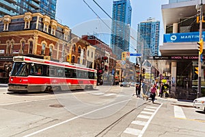 Great view of old street car with fragment of old and modern buildings, walking people in background