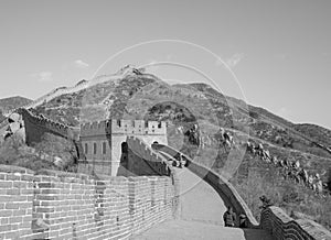 Great Wall of China: Black and white shot of section with towers winding over a mountain ridge under a clear sky