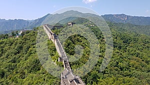 Great Wall of China in a green forest landscape at Mutianyu in Huairou District near Beijing, China.