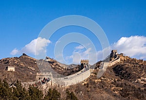 Great Wall of China: section with towers winding across a mountain ridge in winter under a blue sky