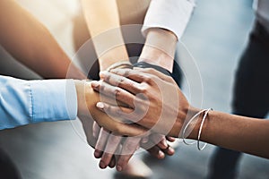 Greatness derives from committed teams. Closeup shot of a group of businesspeople joining their hands together in a