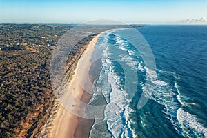 Greatness of the turquoise sea. Foamy ocean waves roll and approach sandy beach. Travel concept photo