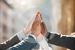 Greatness is what awaits us. a group of businesspeople high fiving one another.