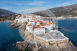 Greece. Andros island Cyclades. Buildings build on cape at Chora town. Sea sun blue sky, above view