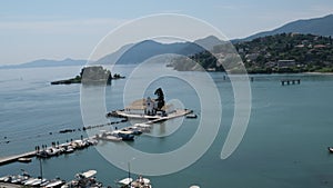 Greece Corfu island Pontikonisi area at Corfu island with airplane flying, Greece. Sailboats in a beautiful bay, Paxos