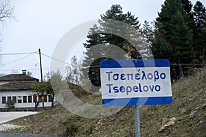Greece, Epirus, Tsepelovo in winter time. Sign with village name, traditional stone building