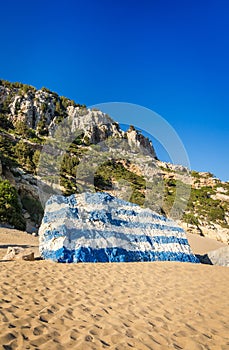 Greece flag painted on Tsambika beach rock