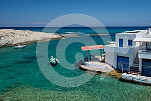 Greece island Milos. Small harbor with fishing boats in water, whitewashed house. Mitakas village