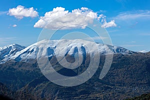 Greece Pindos mountain range. Snowy peak of Pindus misty mountain, blue sky background