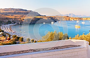 Greece. Rhodes. View from the old town of Lindos to the sea bay with a city beach at sunset