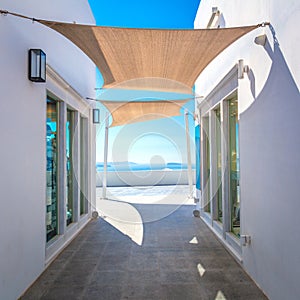 Greece, Santorini island, Oia - white architecture of a narrow street with awnings for shade. Greek Islands, Santorini