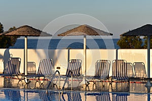 Greece, Santorini, sun beds by a swimming pool.
