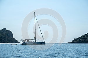 Greece summer vacation. Moored luxury yacht in calm sparkle light blue deep Aegean sea water