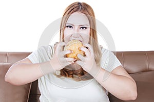 Greedy blonde woman eats hamburger