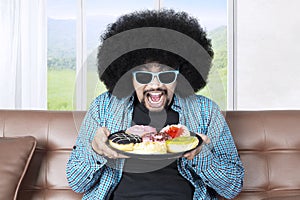 Greedy man holds a plate of donuts