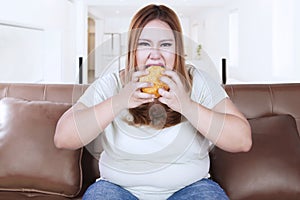 Greedy woman eats hamburger