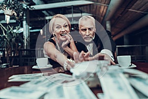 Greedy Woman and Man reach for stack of money