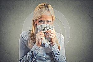 Greedy young woman, holding tight dollar banknotes