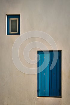 Greek architecture abstract background - whitewashed house with blue painted window blinds