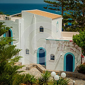 Greek architecture - white buildings, sea and blue windows, Bougainvillea on the white wall