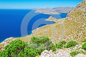 Greek bay with green bushes and blue sky, Greece