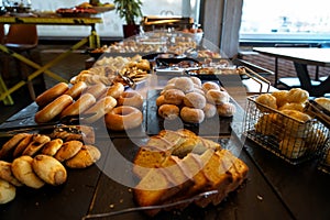 Greek breakfast buffet table full with varieties of pastries, buns, pancakes, donuts, butter cake, pizza, pies, boiled eggs, etc.