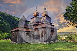 Greek Catholic wooden church of St. Paraskieva in Dobroslava during epic sunrise