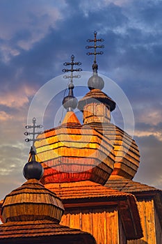 The towers of Greek Catholic wooden church of St. Paraskieva in Dobroslava during epic sunrise