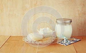 Greek cheese , cottage and milk on wooden table over wooden textured background. Symbols of jewish holiday - Shavuot
