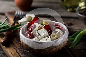 Greek cheese feta with herbs and olives, sundried tomatoes. Bulgarian cheese. Feta in oil. Olove oil. selective focus