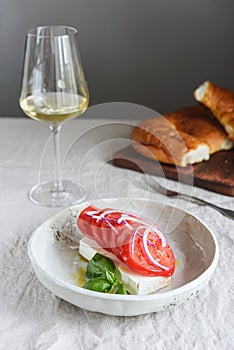 Greek cheese feta with tomatoes, red onion and basil served with wine and fresh baked bread