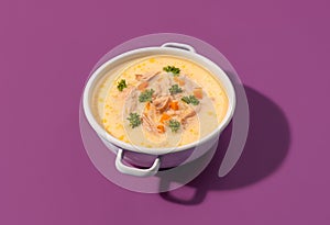 Greek chicken soup with lemon juice, minimalist on a purple background