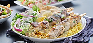 Greek chicken souvlaki platter with pita bread, salad and rice