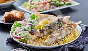 Greek chicken souvlaki platter with pita bread, salad and rice