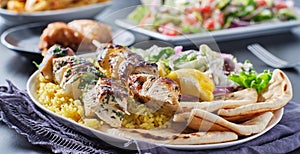 Greek chicken souvlaki platter with pita bread, salad and rice