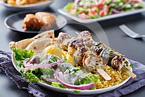 Greek chicken souvlaki platter with pita bread, salad and rice