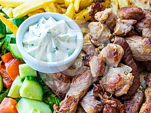 Greek dish with meat, vegetable fries and the famous sauce