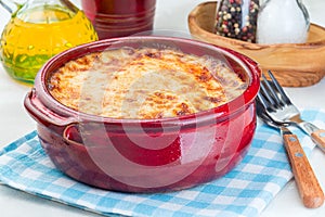 Greek dish moussaka made in  traditional ceramic pot, horizontal, closeup