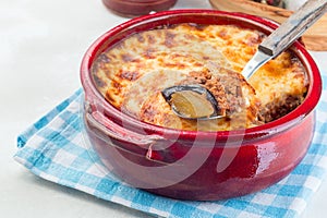 Greek dish moussaka made in a traditional ceramic pot, horizontal, copy space