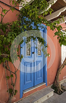 Greek door painted blue on orange wall