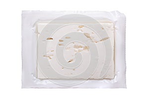 Greek feta block, brined cheese, in its opened original plastic wrap