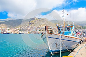 Greek Fishermans' boat standing in harbour with port bui