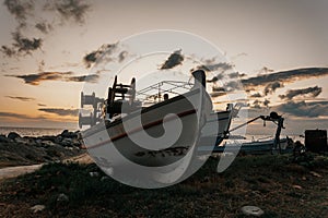 Greek fishing harbor scene with boats, at sunrise on a beautiful tranquil summer day in july