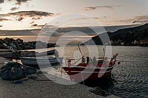 Greek fishing harbor scene with boats, at sunrise on a beautiful tranquil summer day in july