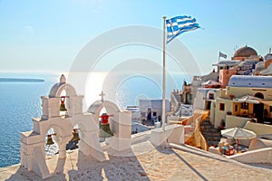 Greek flag and bell tower in Oia village, Santorini, Greece