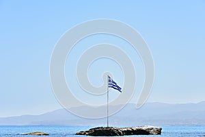 Greek flag on small rocky island near Crete, Greece