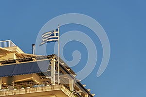 Greek flag waving on a balcony for a national celebration. photo