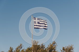 Greek flag in the wind, against blue sky
