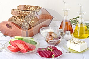 Greek food, mezedes. Jars with olive oil and vine vinegar, olives,feta, tzatziki, dark bread, raki, beetroot, fresh