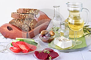 Greek food, mezedes. Jars with olive oil and vine vinegar, olives,feta, tzatziki, dark bread, raki, beetroot, fresh